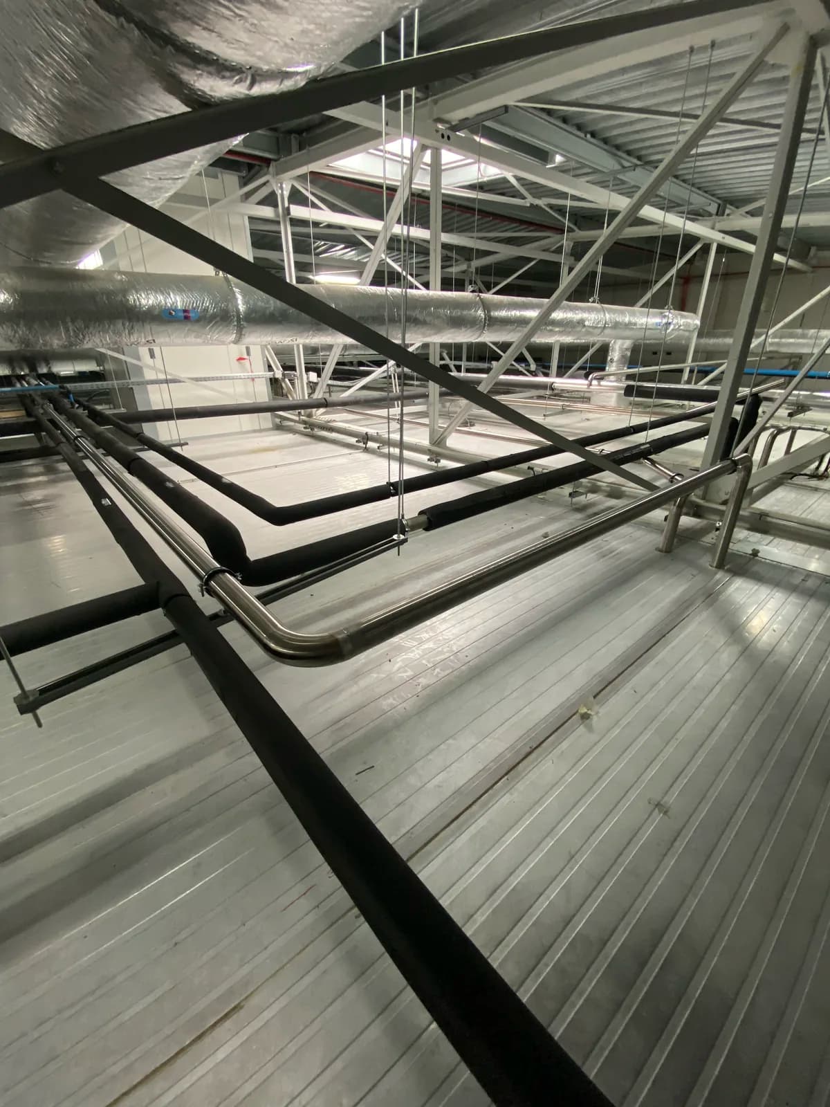 Charpente et supports métalliques portant un réseau de tuyauterie aérien